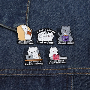 Lot de cinq épingles à chat humoristiques en émail sur denim avec poses et citations