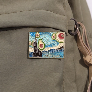 Detail view of Van Gogh Starry Night avocado enamel pin on green canvas backpack