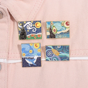 Détail de quatre épingles en émail inspirées de la Nuit Étoilée sur une veste en jean rose