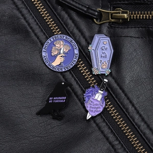 Gothic enamel pins with raven and coffin design pinned on a black leather jacket