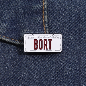 Detail of BORT license plate enamel pin on blue denim fabric with vintage red and white design