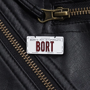 Detailed close-up of a BORT license plate enamel pin on a textured black leather jacket