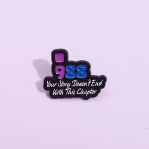 Enamel pin with 988 mental health slogan Your Story Doesn't End With This Chapter