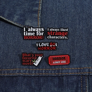 Set of 5 enamel pins featuring horror movie slogans on blue denim fabric texture