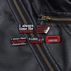 Macro view of five punk horror enamel pins pinned on a black leather jacket