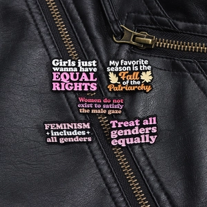Set di cinque spille in smalto femministe con slogan motivazionali su giacca di pelle