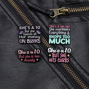 Detail shot of four funny bookworm enamel pins on a black leather jacket texture