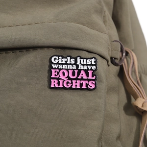 Dettaglio della spilla smaltata su zaino con citazione Girls Just Wanna Have Equal Rights