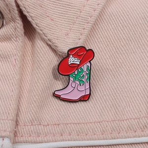 Détail d'une broche en émail avec chapeau de cowboy et botte sur un col en jean