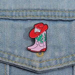 Broche en émail bottes de cow-boy roses et chapeau rouge sur une veste en jean
