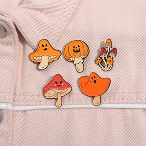 Set of five Halloween mushroom pumpkin enamel pins styled on pink denim jacket