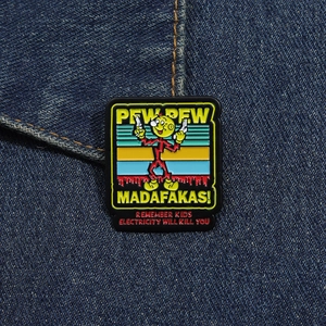Detail of square cartoon enamel pin with colorful stripes on dark blue denim fabric