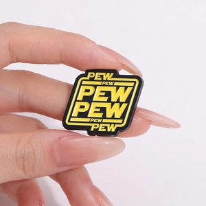 Macro view of black square PVC shoe charm with yellow PEW PEW PEW pop art design