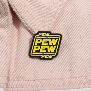 Macro detail of enamel pew pew badge pinned on pink denim jacket showing texture