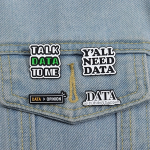 Detail view of four creative metal enamel data badges on a denim jacket pocket