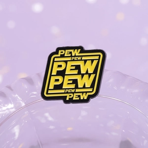 Macro shot of Star Wars parody Pew Pew enamel pin badge with black and yellow finish