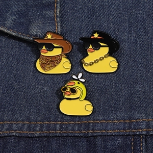 Detailed macro view of yellow enamel duck doctor pins on blue denim fabric