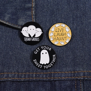 Drei Geister-Emaille-Pins mit lustigen Sprüchen auf blauem Denim-Hintergrund im Detail