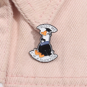 Close-up of duck doctor enamel pin with Trust Me I'm a Ducktor text on pink denim jacket