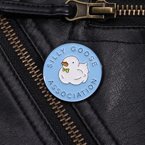 Close-up of a Silly Goose Association enamel pin on a black leather jacket