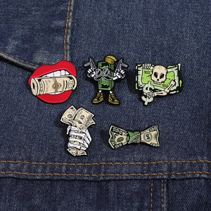 Detailed close-up of 5-piece dollar money enamel pins set on denim fabric background