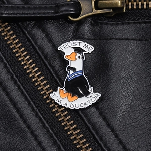 Detail view of Trust Me I'm a Ducktor enamel pin on a black leather jacket