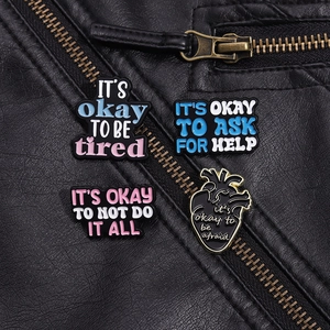 Detailansicht von vier Emaille-Anstecknadeln auf einer schwarzen Lederjacke mit Textur