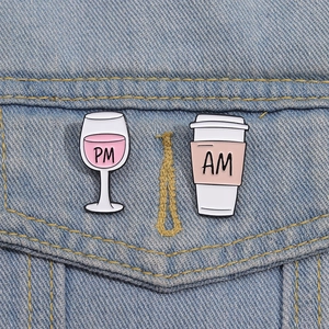 Detailansicht der AM und PM Emaille-Anstecknadeln für Kaffee und Gläser auf Denim