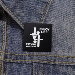 Detail of square enamel pin with funny slogan on denim jacket collar