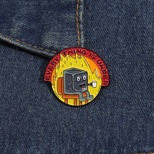 Macro detail of Ctrl button enamel pin with flames on denim background