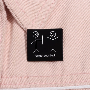 Detail of square enamel pin with 'I've got your back' text on pink denim fabric