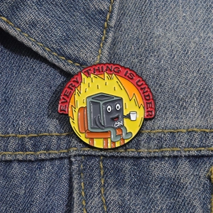 Cartoon Ctrl key enamel pin with fire background pinned on a blue denim jacket pocket