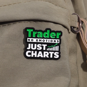 Détail du badge émaillé Trader avec design de graphique boursier sur un sac à dos