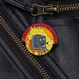 Close-up of funny enamel pin featuring Ctrl button and fire on a black leather jacket