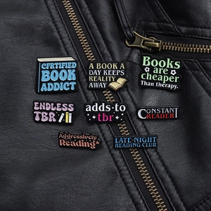 Detailed view of eight colorful enamel reading pins attached to a black leather jacket