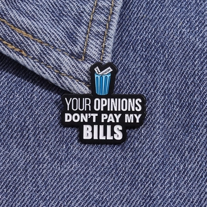 Gros plan d'un pin's en émail avec message humoristique sur une veste en jean bleue