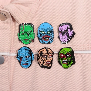 Set of 6 colorful horror monster enamel pins displayed on a pink denim jacket