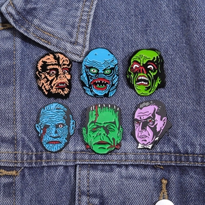 Set of 6 classic horror monster enamel pins displayed on blue denim jacket fabric