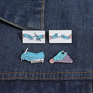 Details von medizinischen Emaille-Pins mit Skalpell und Spritze auf Denim-Hintergrund