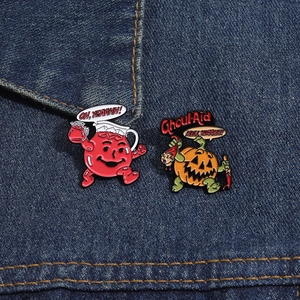 Detail of Halloween pumpkin ghoul and cartoon enamel pins on blue denim fabric background