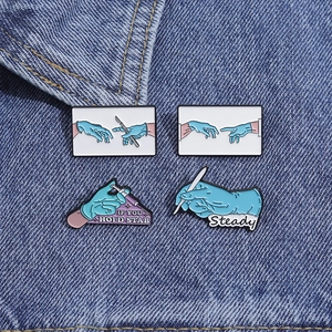 Detailansicht von vier medizinischen Emaille-Pins mit Skalpell und Spritze auf Denim