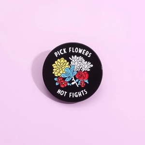 Cartoon enamel pin featuring flowers and 'Pick Flowers Not Fights' text on purple background