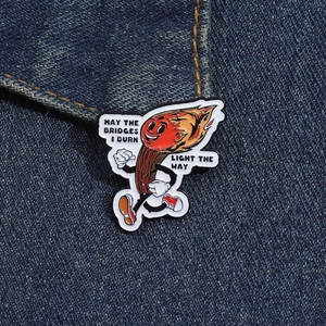 Detailaufnahme der Emaille-Streichholz-Anstecknadel mit humorvollem Spruch auf Denim