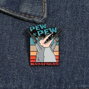 Detail of cartoon opossum enamel pin with guns on blue denim background