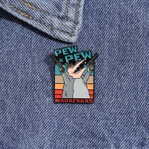 Detail of cartoon opossum enamel pin with PEW PEW text on dark blue denim fabric