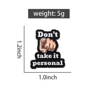 Detail view of cartoon enamel pin with Don't take it personal quote and finger gesture