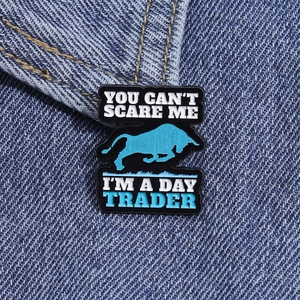 Détail d'un pin's en émail taureau bleu sur denim avec texte Day Trader