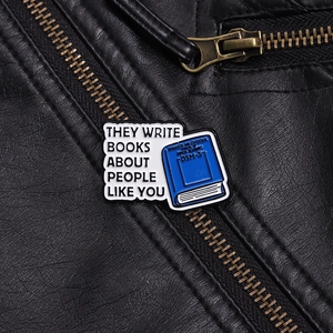 Detalle macro del pin esmaltado de libro DSM-5 sobre una chaqueta de cuero negra