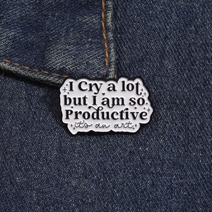 Detail der kreativen Emaille-Anstecknadel mit Spruch auf blauem Jeansstoff