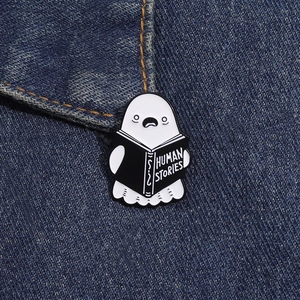 Close-up of ghost reading Human Stories enamel pin on dark blue denim fabric pocket